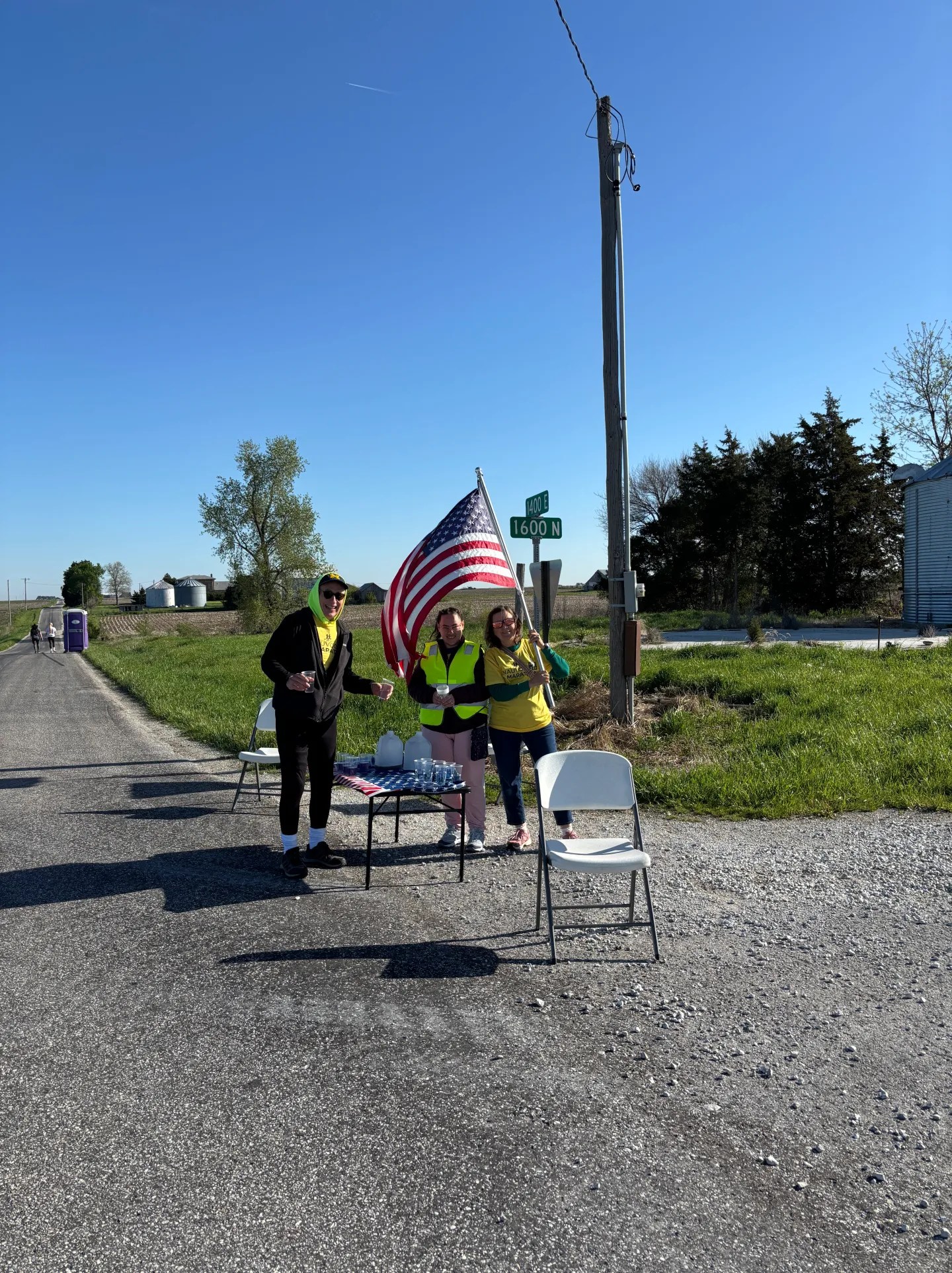 Volunteers at aid station waiving flag.