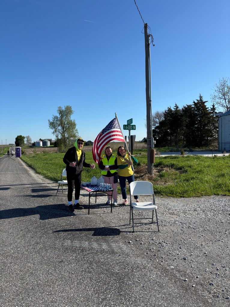 Aid station volunteers waiving American Flag